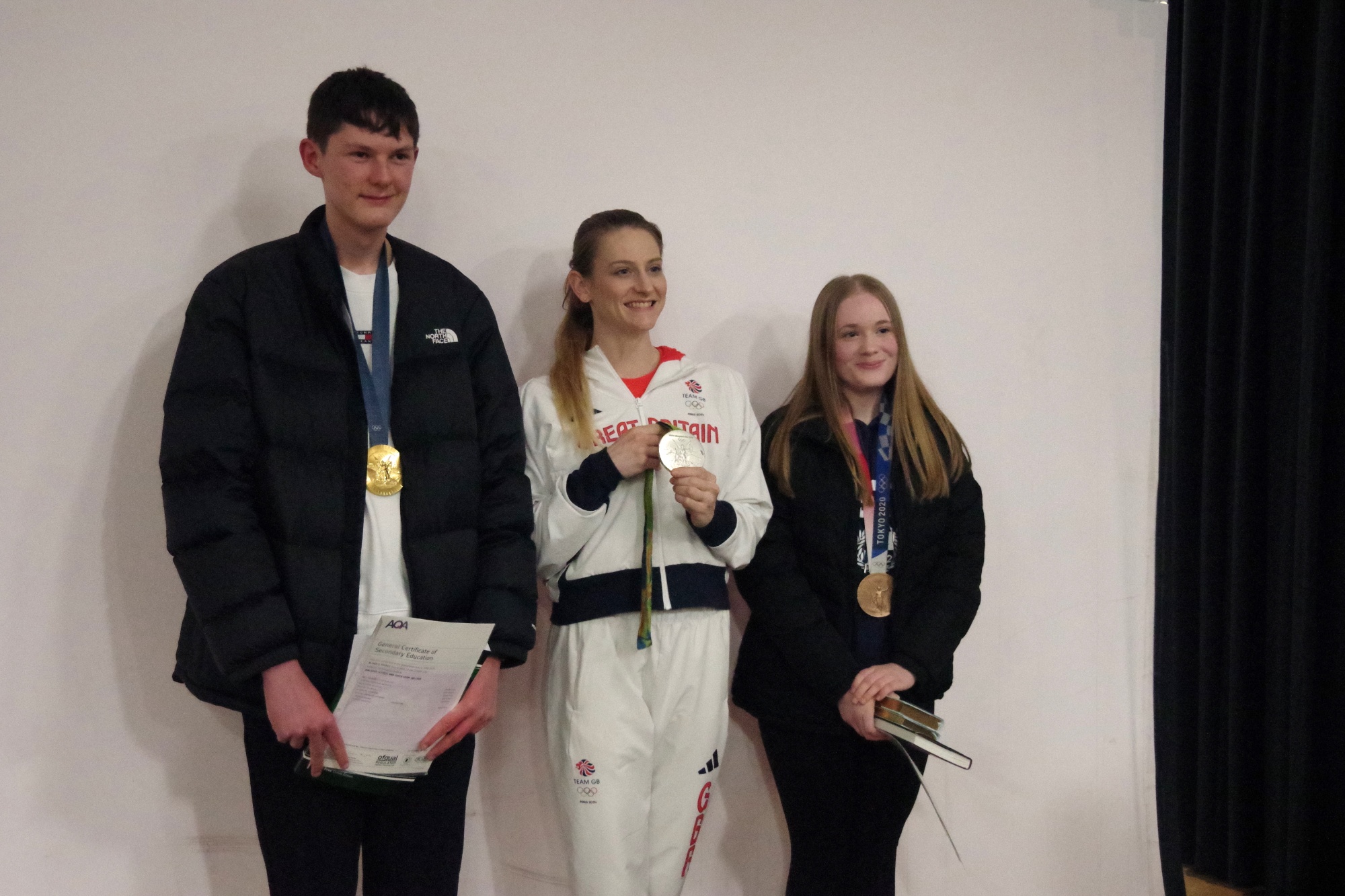 Photograph of students collecting GCSE certificates and Bryony Page