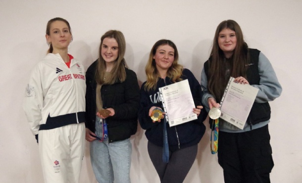Photograph of students collecting GCSE certificates and Bryony Page
